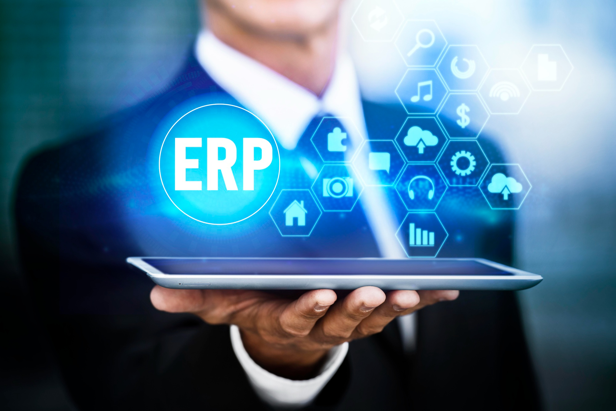Empresário segurando um tablet com ícone de ERP em destaque, representando sistema de gestão empresarial integrado e automação de processos corporativos. Imagem de capa para o blogpost O que é um sistema ERP e como ele facilita a gestão financeira da sua empresa